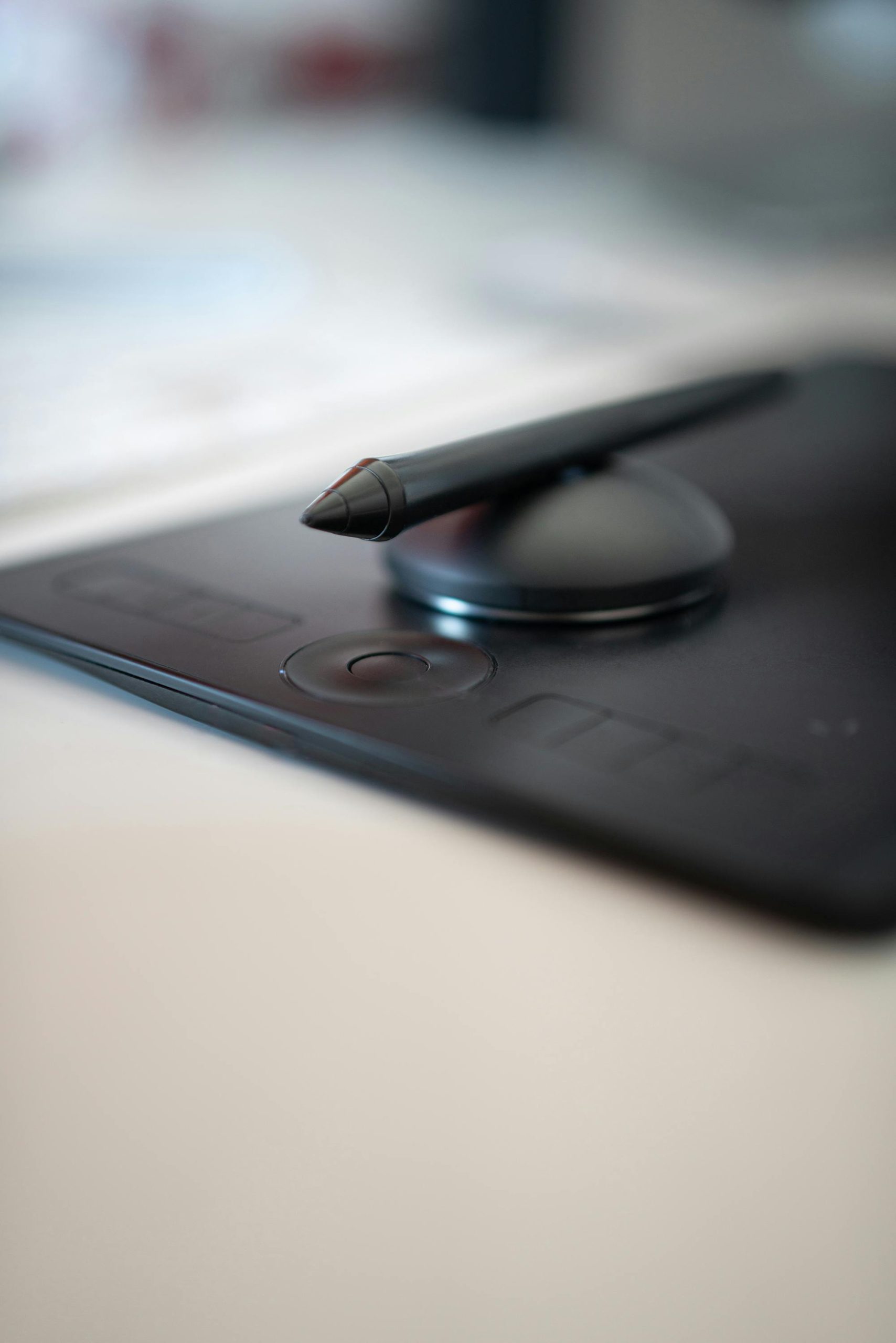 Close-up of a stylus on a black drawing tablet. Perfect for digital art and design work.